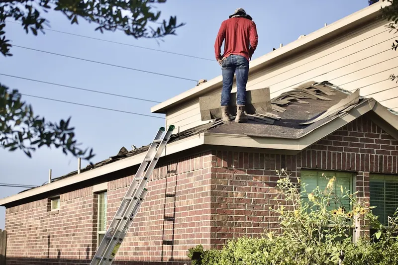 Professional roofer working on a residential roof in Stark